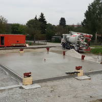 Es ist geschafft: Der erste Teil der Bodenplatte ist fertig und die Bodenanker der Holzpfeiler für die Wände sind auch schon dabei.